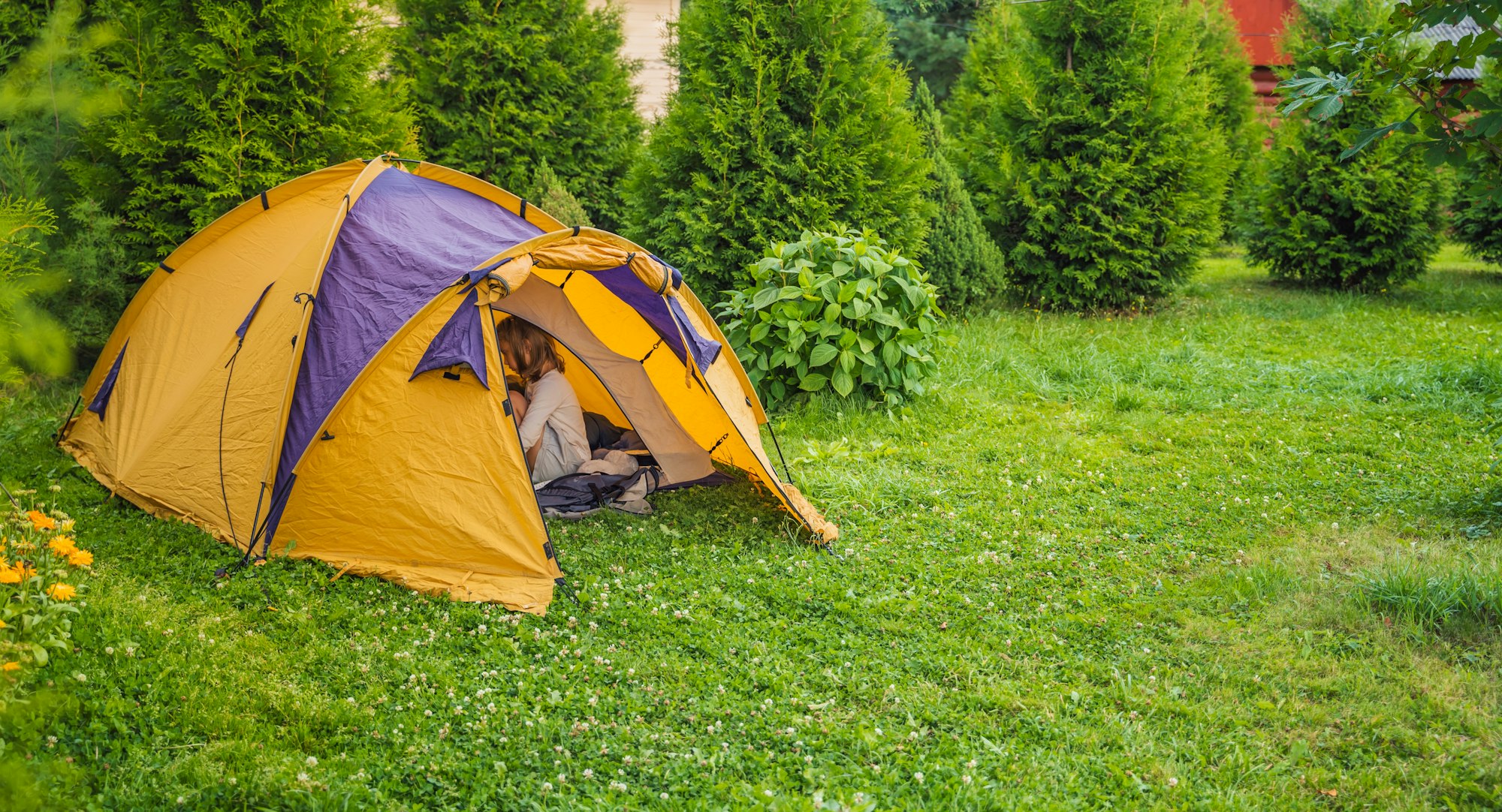 Small children, kids play, read in orange tourist tent. Family trip, hike to nature. Backyard games,